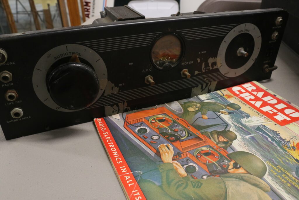 The front of an old Recordgraph player next to a copy of a RadioCraft magazine from the same time period